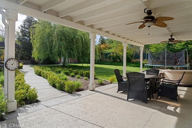 view of patio with a ceiling fan, a trampoline, and outdoor dining area