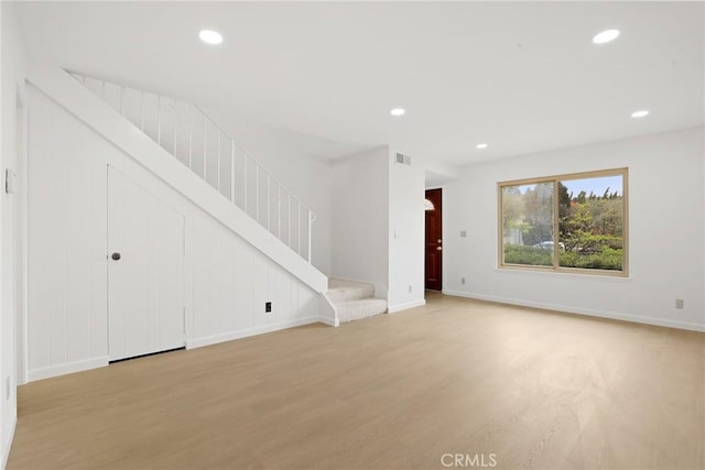 unfurnished living room with visible vents, recessed lighting, and stairs