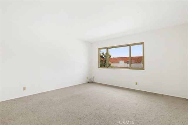 carpeted empty room with baseboards