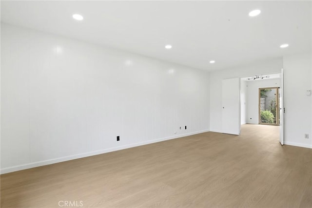 unfurnished room featuring light wood-style floors, baseboards, and recessed lighting