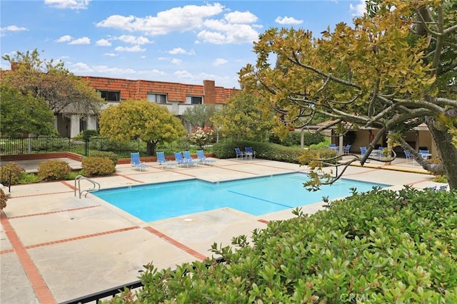 community pool featuring fence and a patio
