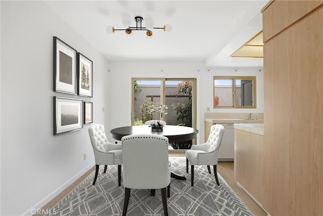 dining room featuring baseboards, wood finished floors, and a notable chandelier