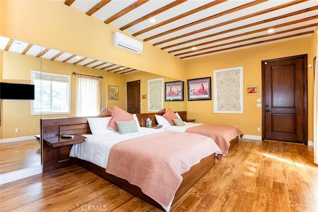 9336 Wayside Dr, Sunland, CA 91040 - bedroom with beam ceiling, light wood finished floors, an AC wall unit, recessed lighting, and baseboards