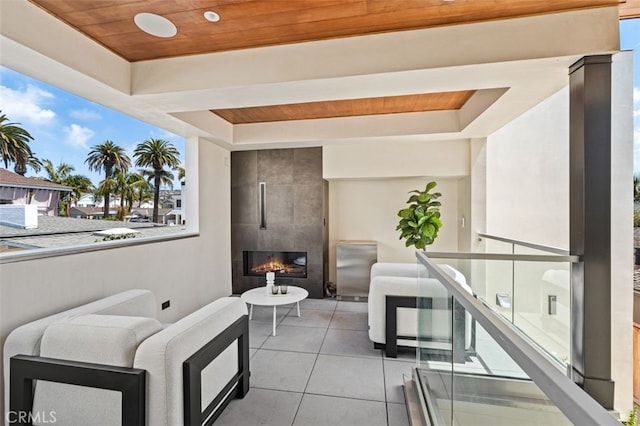 balcony with an outdoor living space with a fireplace and a patio