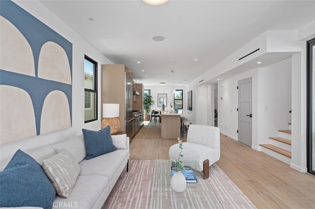 living area with light wood-style floors, recessed lighting, baseboards, and stairway