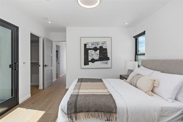 bedroom with baseboards, recessed lighting, and wood finished floors