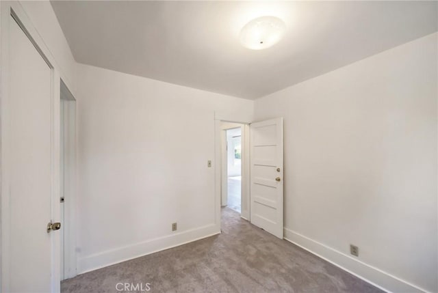 carpeted empty room with baseboards