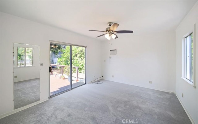 empty room featuring carpet flooring, a ceiling fan, and a wealth of natural light