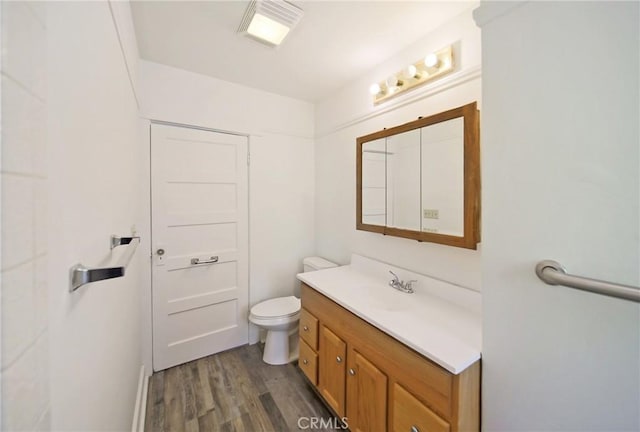 bathroom featuring vanity, toilet, wood finished floors, and visible vents