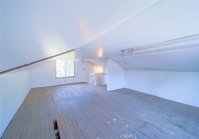 additional living space featuring hardwood / wood-style floors and lofted ceiling