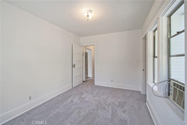 unfurnished bedroom featuring baseboards, carpet, and cooling unit