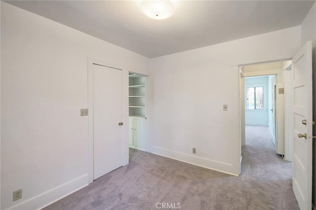 carpeted spare room featuring baseboards