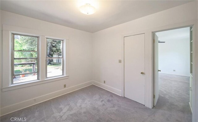 empty room featuring carpet floors and baseboards