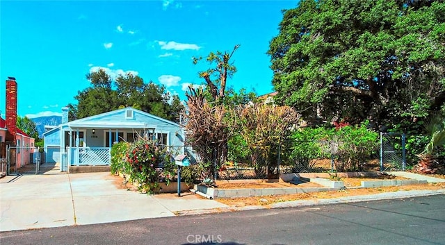 view of front facade with fence, a gate, and covered porch