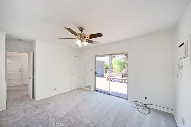 spare room featuring light carpet and a ceiling fan
