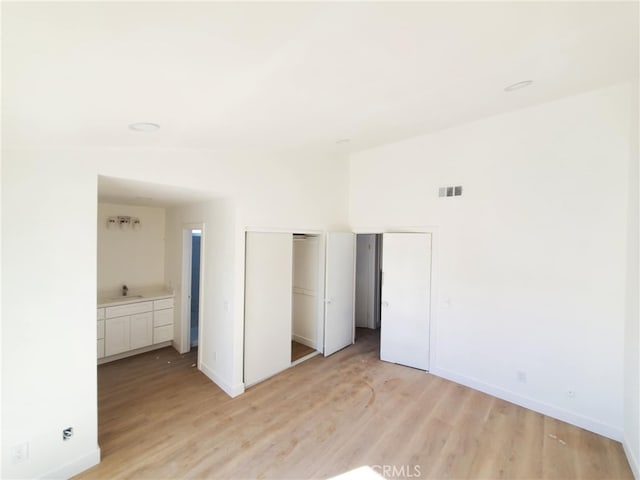 unfurnished bedroom with baseboards, visible vents, and light wood-style flooring