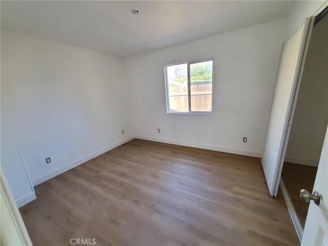 unfurnished bedroom featuring light wood-style floors and baseboards