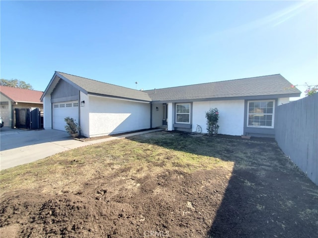 ranch-style house featuring a garage, fence, stucco siding, and concrete driveway