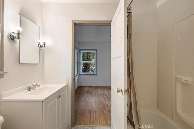 bathroom featuring vanity, wood finished floors, and shower / bath combo with shower curtain