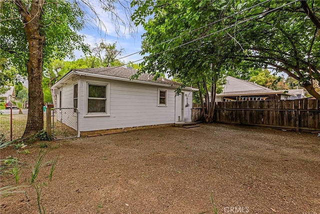 back of property featuring fence and a shingled roof