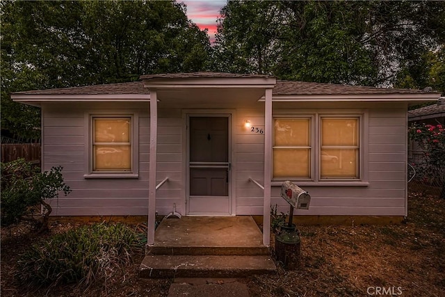 bungalow-style home featuring fence and a shingled roof