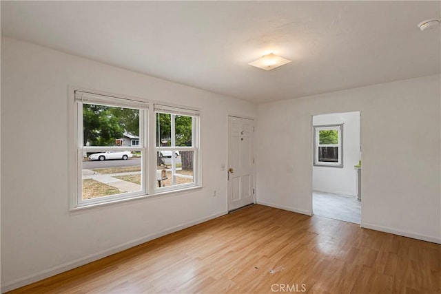 empty room with baseboards and light wood-style floors
