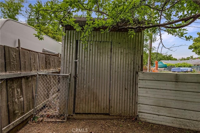 view of outdoor structure featuring fence and an outbuilding