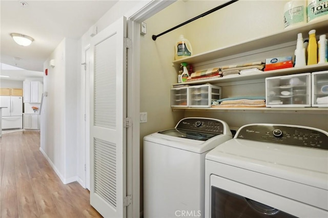 1900 Danbrook Dr Unit 521, Sacramento, CA 95835 - washroom with washer and clothes dryer, light wood-style flooring, and baseboards
