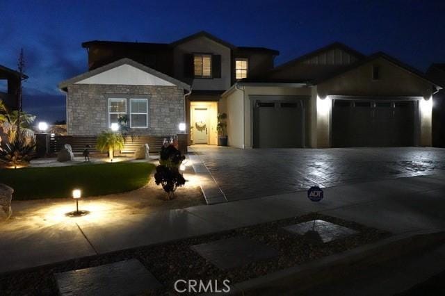 13504 Planet Ct, Riverside, CA 92503 - view of front of house featuring an attached garage, stone siding, and decorative driveway