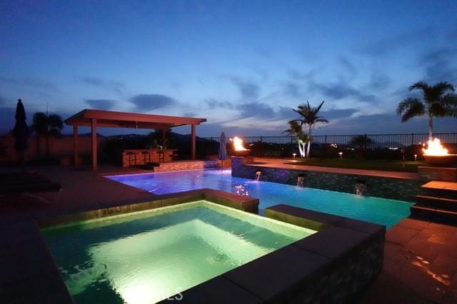13504 Planet Ct, Riverside, CA 92503 - pool at dusk with a fenced backyard, a patio, and a pool with connected hot tub