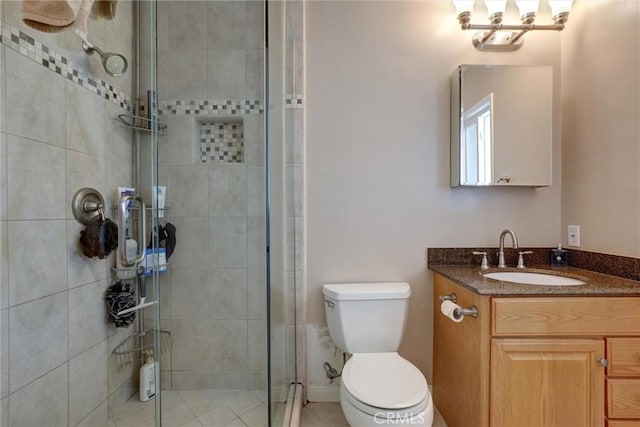 bathroom with vanity, a stall shower, and toilet