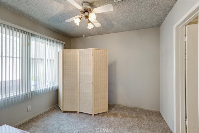unfurnished bedroom with carpet floors, a ceiling fan, and a textured ceiling