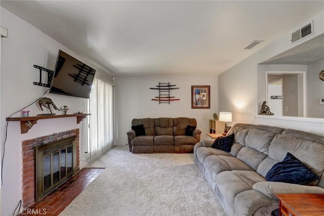 carpeted living room with a brick fireplace and visible vents