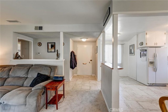 living room with light colored carpet, baseboards, visible vents, and light tile patterned floors