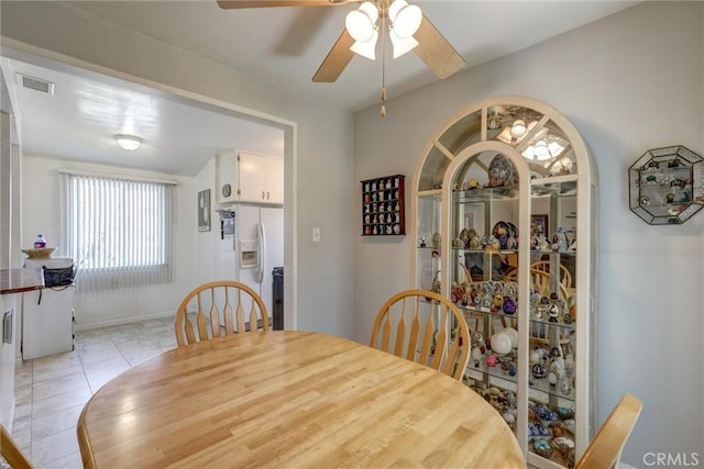 dining area with baseboards, ceiling fan, visible vents, and light tile patterned floors