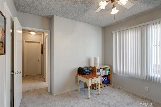 office area with a ceiling fan, carpet, a textured ceiling, and a wealth of natural light