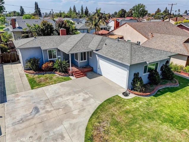 view of front of property with roof with shingles, a front lawn, stucco siding, a chimney, and driveway