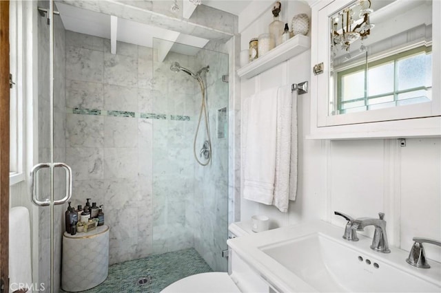 full bathroom featuring toilet, a sink, and a stall shower