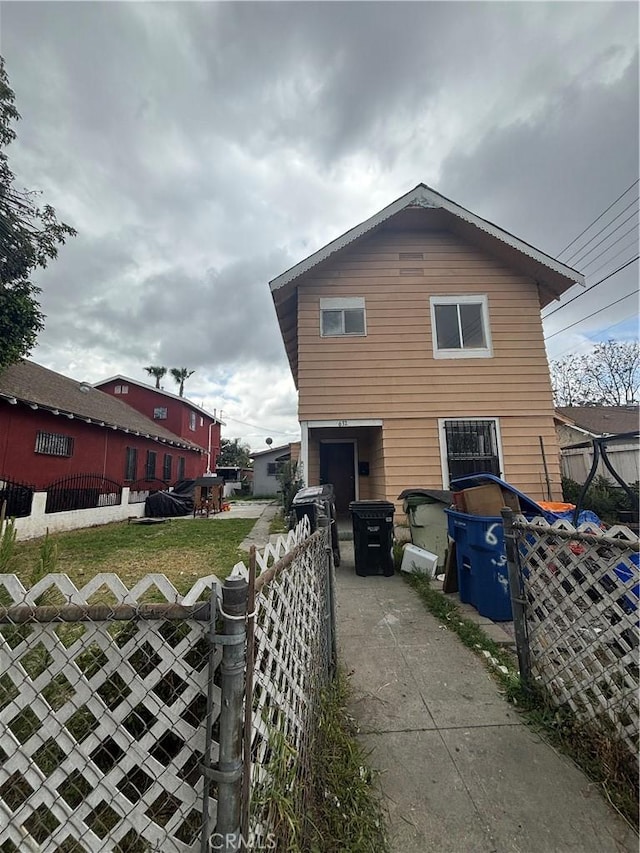 view of side of home with concrete driveway and fence