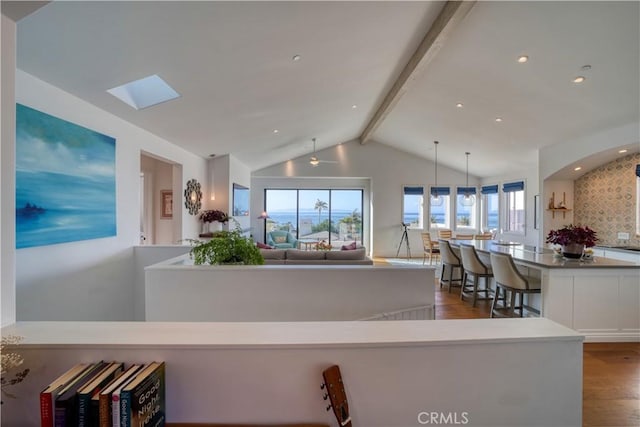 interior space featuring vaulted ceiling with skylight and dark wood-style flooring