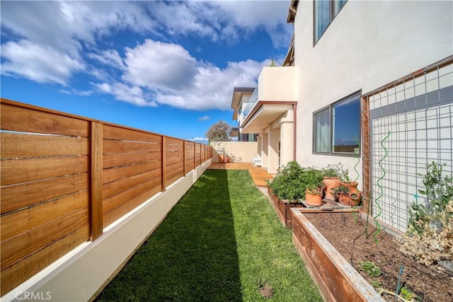 view of yard featuring a fenced backyard and a garden