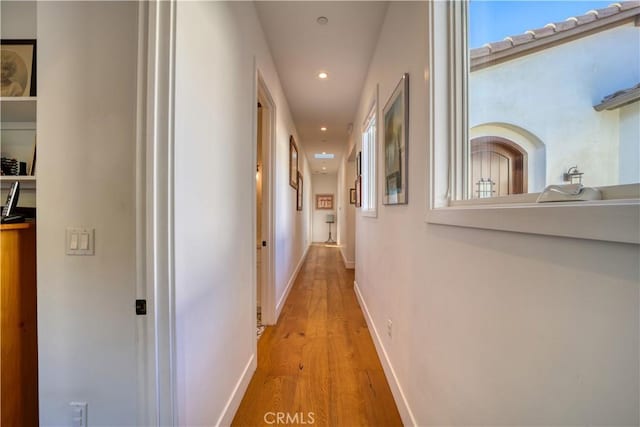 hall featuring recessed lighting, baseboards, and light wood finished floors