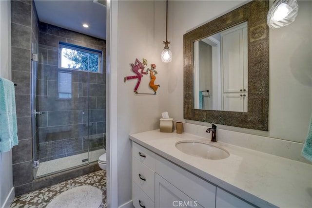 full bathroom featuring vanity, a shower stall, and toilet