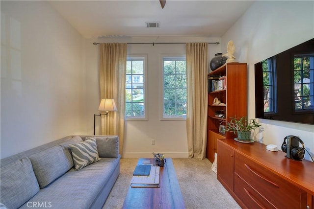 living area with light colored carpet, baseboards, and visible vents