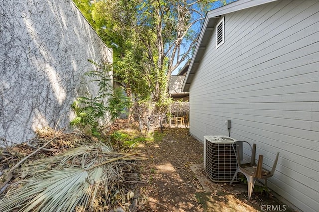 view of side of home featuring fence and cooling unit