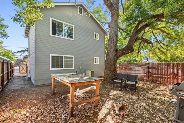 back of house with a fenced backyard and cooling unit