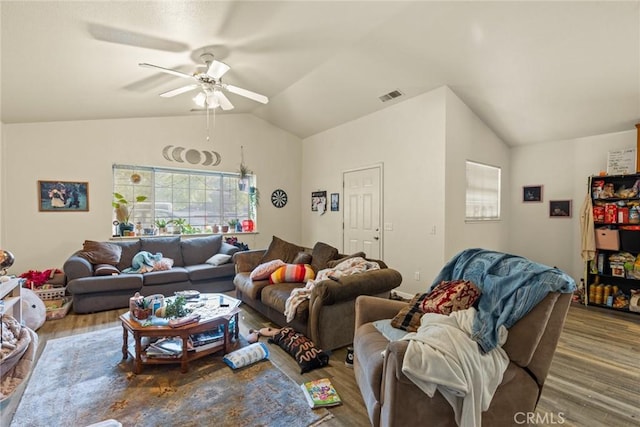 living room with a healthy amount of sunlight, lofted ceiling, wood finished floors, and visible vents