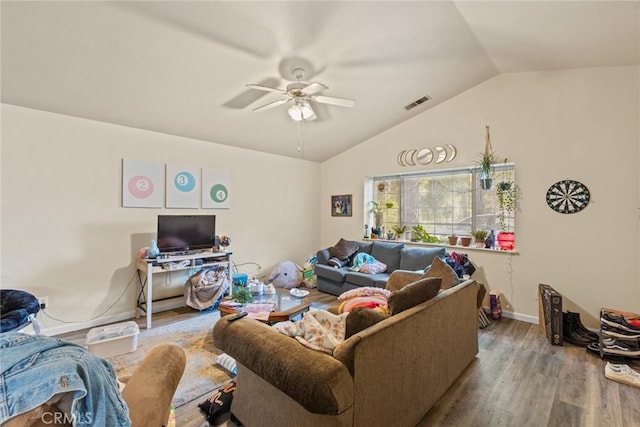 living area with visible vents, wood finished floors, baseboards, ceiling fan, and vaulted ceiling