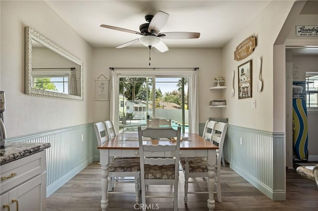 dining space with plenty of natural light, ceiling fan, wainscoting, and light wood-type flooring
