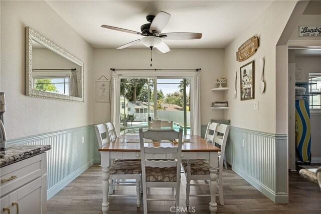 11414 Golden Gate Dr, Yucaipa, CA 92399 - dining area with light wood-style floors, ceiling fan, and a wainscoted wall